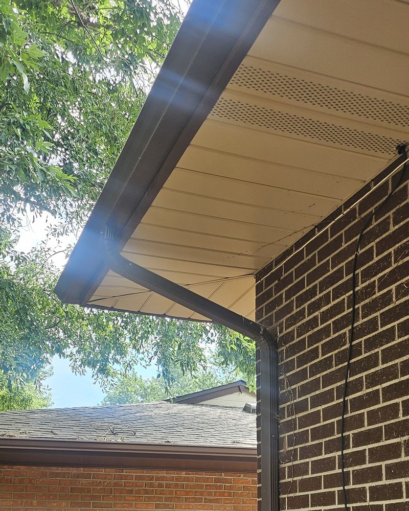 Brown gutter and downspout on a brick home